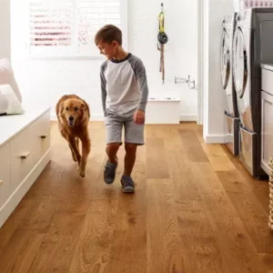 Boy running with his dog on hardwood floors