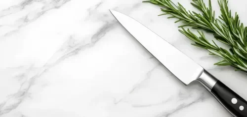 Knife laying on white marble patterned quartzite coutertop